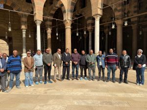 فريق من الآثاريين يلتقط صورة جماعية أمام الأعمدة الأثرية في قلعة صلاح الدين.