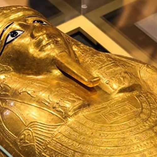 تابوت ذهبي مائل أو موضوع في صندوق التغليف المبطن الخاص بالترميم/النقل